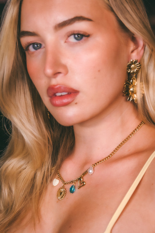 Close-up of a woman wearing gold jewelry with a dark background