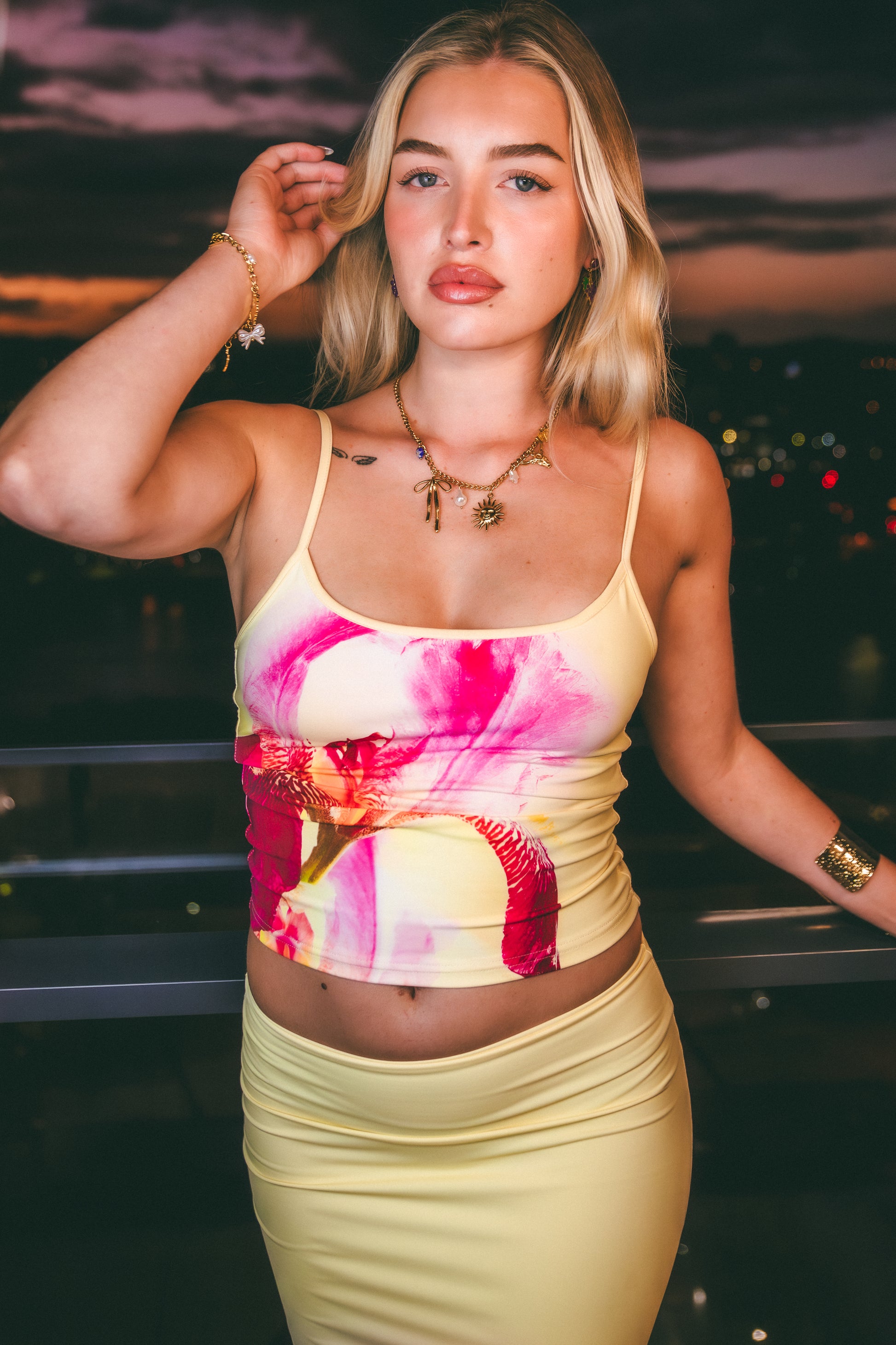 Woman wearing a colorful top and skirt with a cityscape background